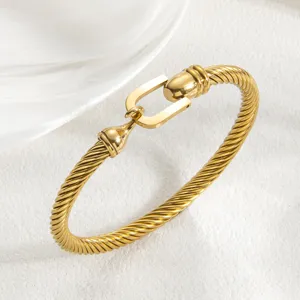 Gold titanium steel horseshoe buckle twist cuff bracelet, elegant minimalist luxury chic style.