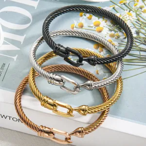 Detailed shot of trendy stainless steel horseshoe U-hook cable chain bracelets stacked.