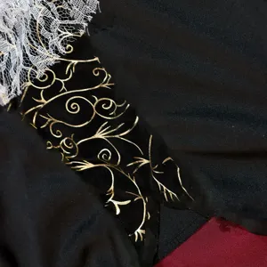 Kids Halloween pirate costume detail shot, black fabric with gold print and lace.