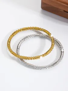 Nahaufnahme von goldenen und silbernen Perlenarmbändern mit feiner Textur und edlem Design.