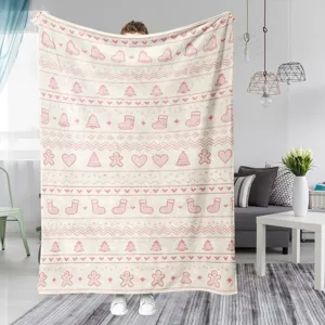 Detailed view of cozy pink Christmas pattern flannel blanket displayed in modern living room setting.