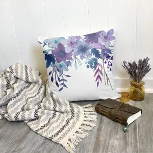 Gros plan de la housse de coussin lavande avec motif floral aquarelle et décor chaleureux.