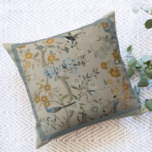 Detailed view of the vintage botanical flower and bird pattern cushion cover on fabric surface.