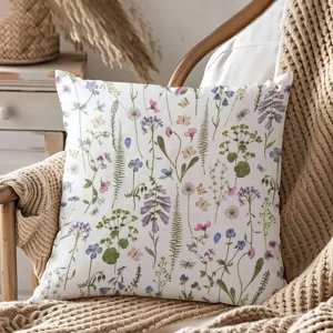 Detailed view of pastoral watercolor wildflower throw pillow on cozy knit chair decor.