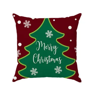 Christmas cushion cover detail showing red fabric, green tree pattern and snowflakes.