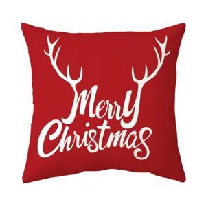 Close-up detail of the red Christmas pillow cover with white reindeer antlers and text print.