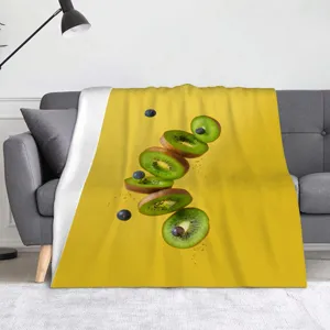 Primo piano di una coperta in flanella colorata con un motivo di kiwi e mirtillo fresco.