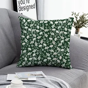 Detailed view of the dark green floral cushion cover, lifestyle scene on gray sofa couch.