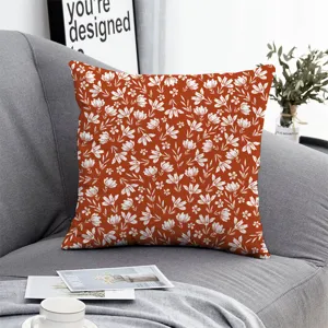 Decorative floral pillow cover with rust orange and white botanical print for sofa.