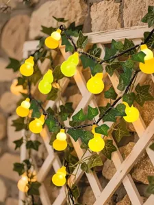 Detailed view of solar gourd string lights with green ivy leaves for garden and balcony decor.