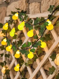 Gourd string lights with green ivy vine leaves, warm decorative LED lights for garden and balcony.