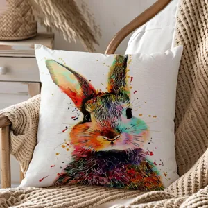 Dettaglio del cuscino decorativo con coniglietto di pasqua acquerello su coperta in maglia.