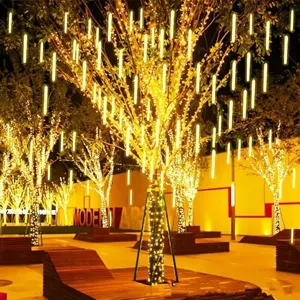 Outdoor LED meteor shower rain light strings hanging on trees for holiday street lighting decoration.