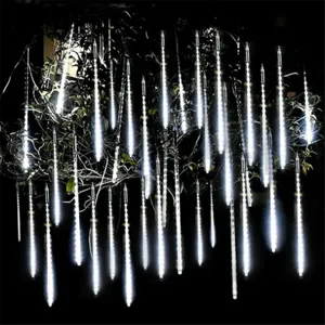 Detailed shot of outdoor LED meteor shower lights glowing on tree branches at night.