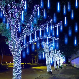 Outdoor waterproof LED meteor shower light string glowing blue on street trees at night scene.