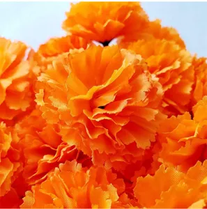 Detailed close-up view of vibrant orange artificial marigold flower petals texture design.