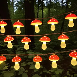 Close up of glowing red mushroom fairy string lights hanging in forest for cozy holiday decor.