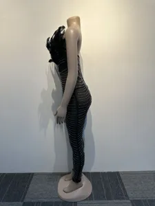 Side detail view of black feather spliced rhinestone tight jumpsuit showcasing fabric texture.