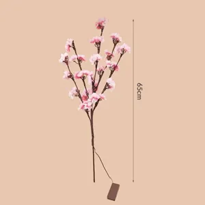 Vue détaillée de la branche de cerisier artificielle lumineuse de 65cm avec des fleurs.
