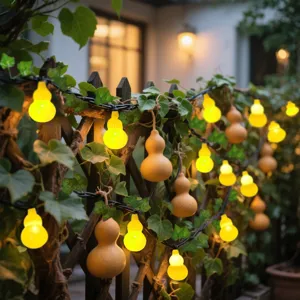 Solar gourd string lights with green leaves for outdoor garden balcony decor and landscape lighting.