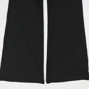 Detalle del dobladillo del pantalón negro, primer plano con costuras finas y tela suave.