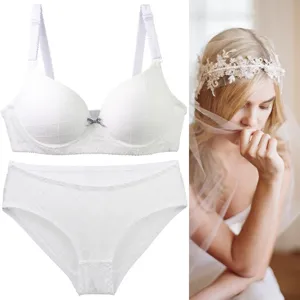 White lingerie set detail showing textured bra and panties with a cute bow for women.