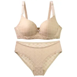 Detailed view of a comfortable nude bra and panty set with a delicate grid pattern and bow.