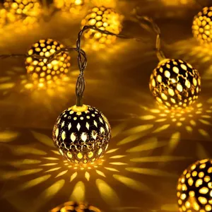 Moroccan metal ball LED string light detail, warm glowing hollow sphere decorative fairy lights.