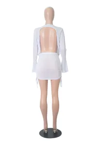 Sexy white sheer mesh two-piece outfit featuring backless long sleeve top and ruched mini skirt.