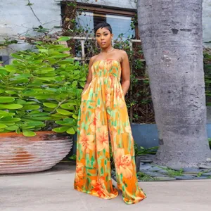 Detailed outdoor view of the vibrant orange floral print strapless wide-leg jumpsuit.