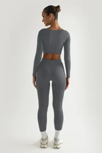 Λεπτομερής εικόνα του σκούρου γκρι ριμπ crop top μακρυμάνικου και ασορτί κολάν γιόγκα σετ.