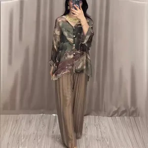 Completo chic da donna con camicia stampata a maniche lunghe e pantaloni larghi plissettati.