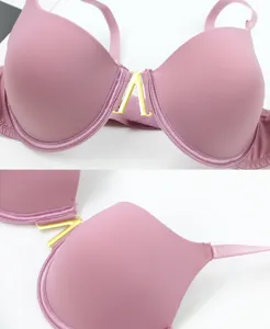 Close-up detail of sexy underwire pink seamless bra with stylish gold metal V-buckle accent.
