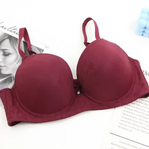 Detailed view of a maroon padded bra featuring textured floral patterns and a crystal pendant.