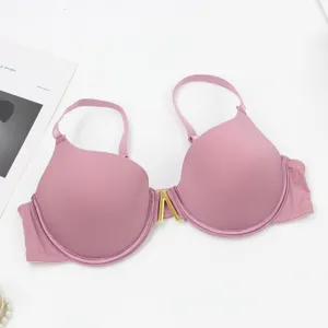 Close-up detail of sexy solid color seamless push-up underwire bra with gold metal clasp.