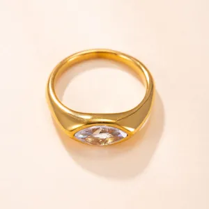 Primer plano de un anillo de acero chapado en oro con una circonita clara de corte marquesa