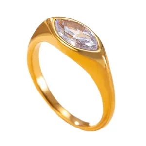 Anillo de acero inoxidable dorado con circón de talla marquesa en fondo blanco.