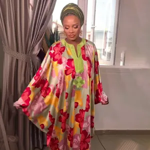 Gedetailleerd uitzicht op de Afrikaanse maxi-jurk met bloemenprint en hoofddoek.