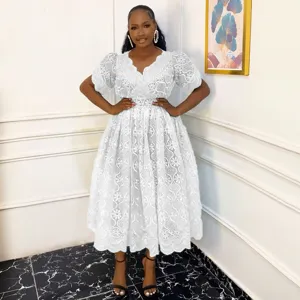 Detail view of the elegant white lace hollow-out V-neck puff sleeve dress worn by model.
