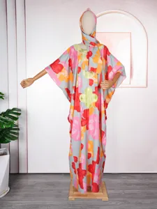 Gedetailleerd uitzicht op de elegante lange jurk met bloemenprint en hoofddoek.