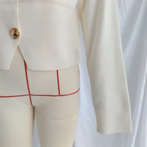 Primer plano detallado del cárdigan de punto liso minimalista para mujer, botones dorados.