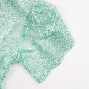Mint green lace dress detail, delicate floral embroidery, elegant hollow sleeve trim.