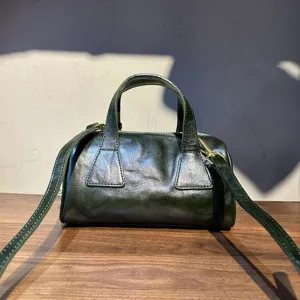 Détail de sac Boston en cuir vert foncé, texture de sac à main vintage, style bandoulière.
