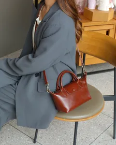 Retro brown genuine leather dumpling bag, versatile crossbody handbag for stylish women.