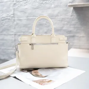 Cream white genuine leather Kelly handbag detail view showing metal zipper and handle.