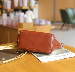 Retro genuine leather dumpling handbag, versatile crossbody small bag with vintage style details.