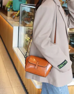Detail shot of retro brown leather shoulder bag, showcasing fine texture and hardware.