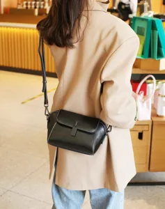 Black leather shoulder bag detail shot, vintage style flap crossbody bag for women.