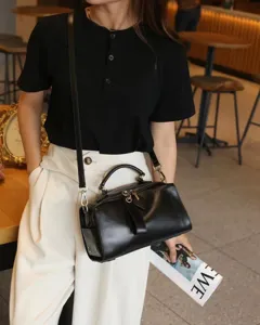 Black genuine leather pillow bag detail, vintage shoulder handbag, daily casual fashion style.