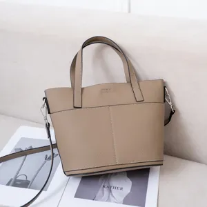 Λεπτομέρεια της δερμάτινης τσάντας tote σε taupe χρώμα, με υφή δέρματος και διπλές λαβές.